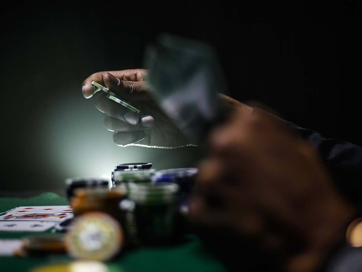 A poker player throwing in some chips with an LED glow in the background.